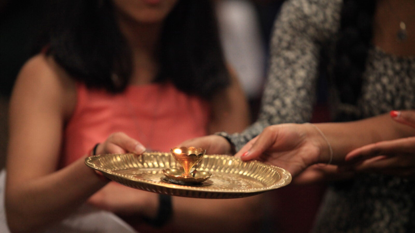 Students sing bhajans (hymns) while encircling the Icons with a ghee-lamp in the Hindu ritual of aarti, which asks God to bless the devotee’s heart and mind with love and compassion.