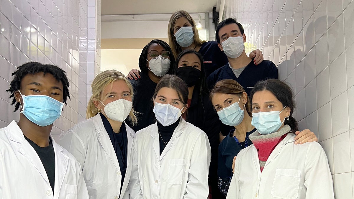 a group of doctors in masks and white coats look at the camera