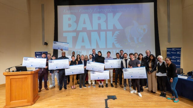 students holding giant checks at bark tank