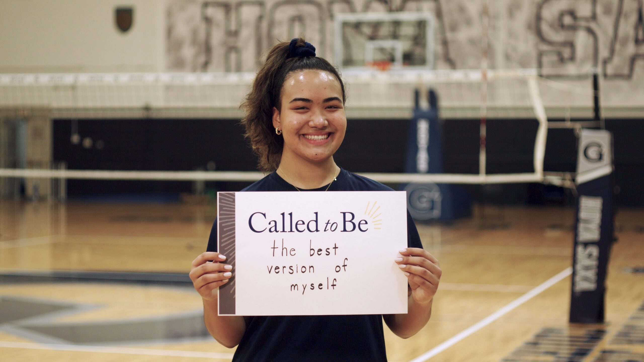 Vaughan Anoa’i (C'26) holding a sign that states 