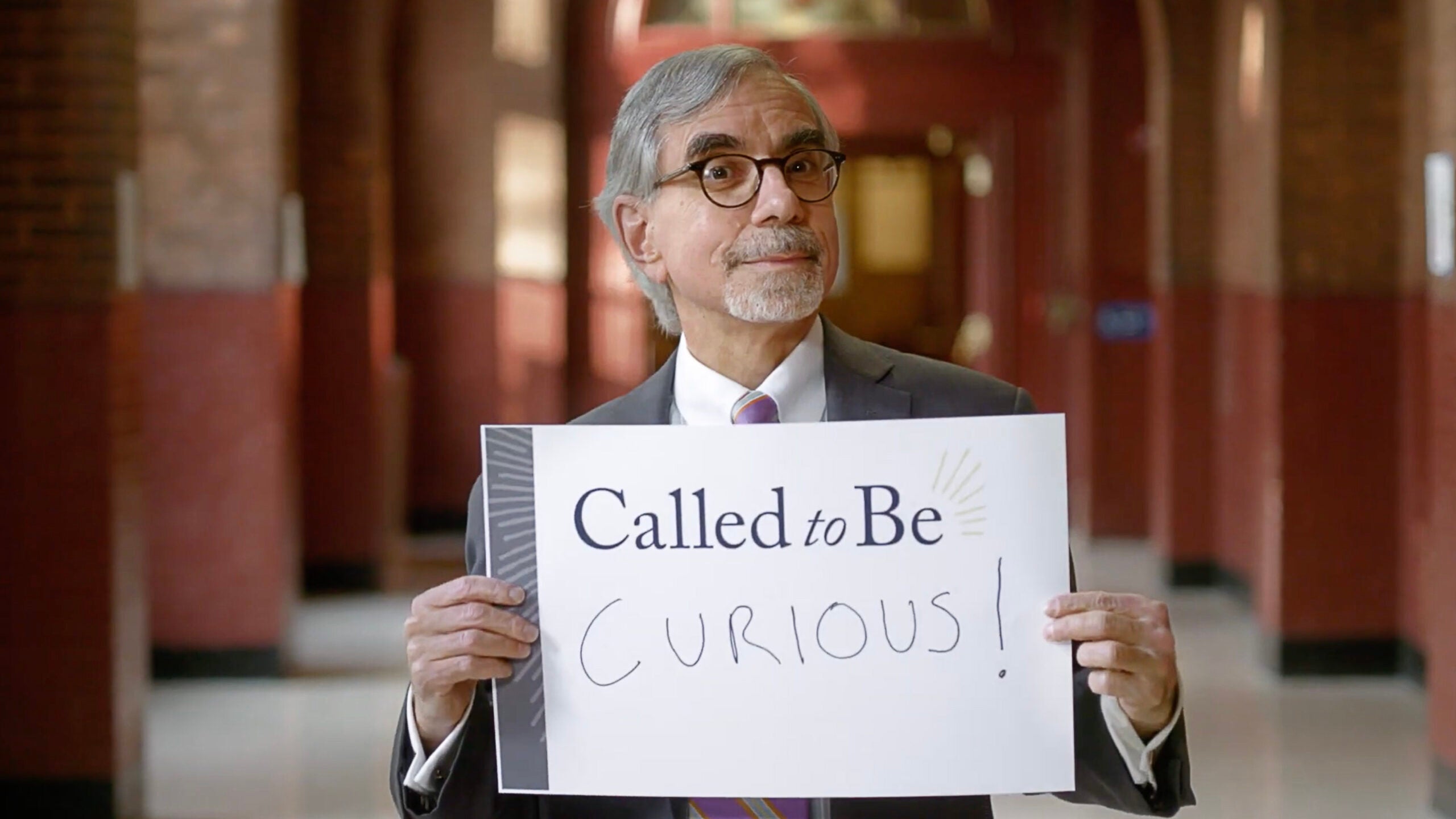 Professor Anthony C Arend holding a sign stating 