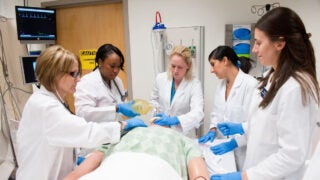 students practicing on medical doll
