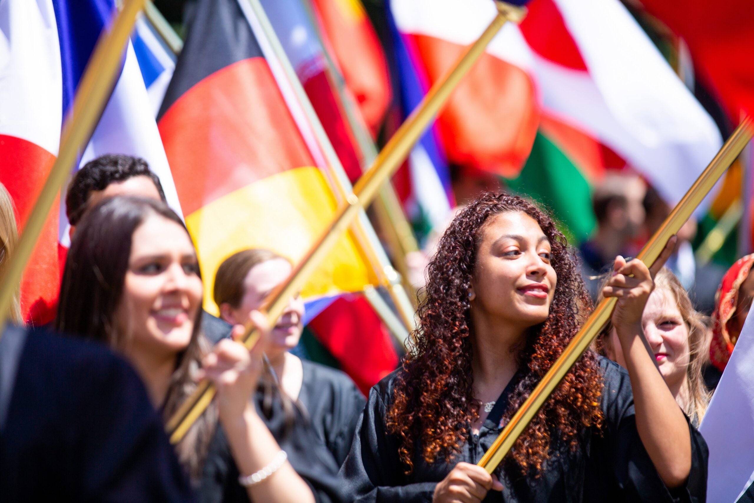 students at graduation with world flags