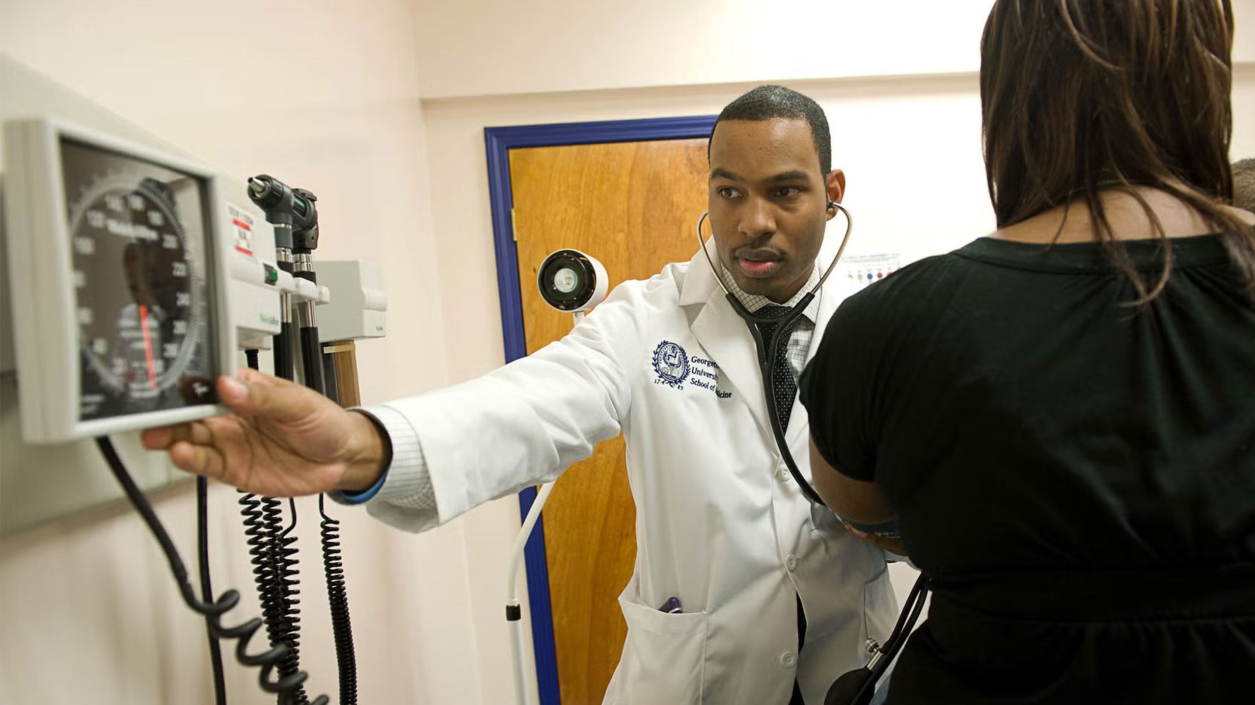 doctor gesturing to a medical measurement machine