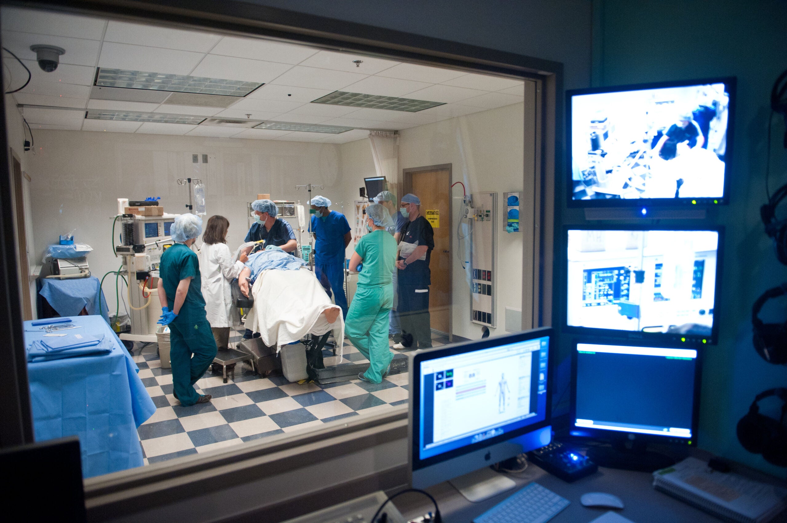 nursing students in a simulation lab around a patient bed