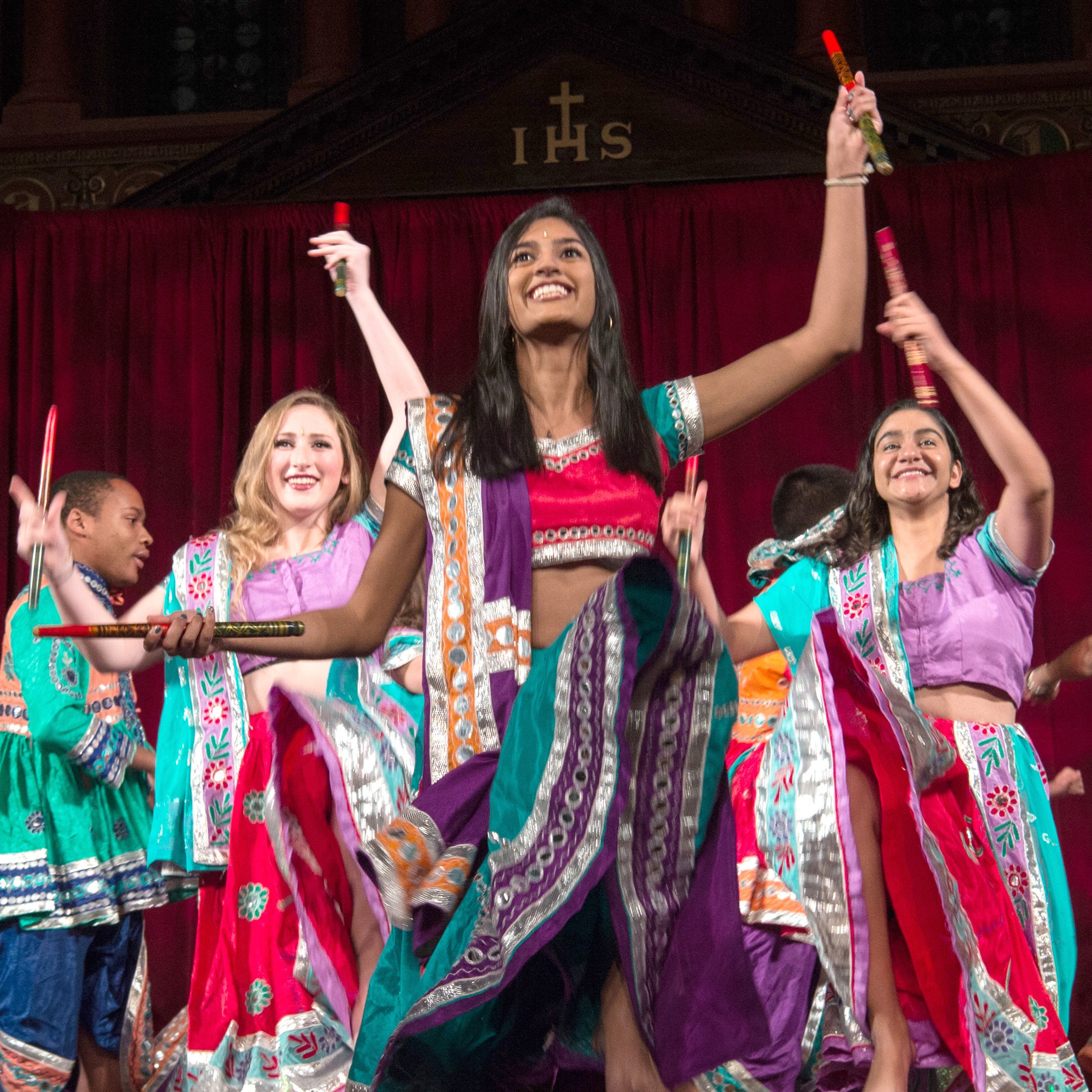 students dancing on stage in colorful bhangra garb